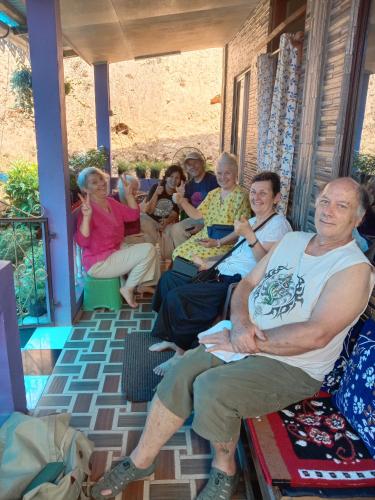 a group of people sitting on a porch at Lopchan Homesstay in Darjeeling