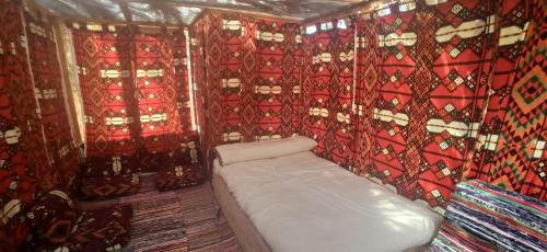 una piccola stanza con un divano bianco in una stanza con tende di Siwa Gardenia Cottage اكواخ سيوة جاردينيا a Siwa