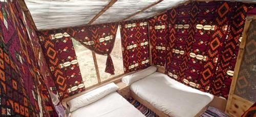 una piccola stanza con un letto e delle tende di Siwa Gardenia Cottage اكواخ سيوة جاردينيا a Siwa