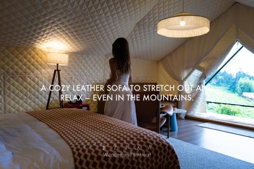 a woman standing next to a bed in a room at BZIKA Wonderland Retreat--Zhangjiajie National Forest Park Store in Zhangjiajie