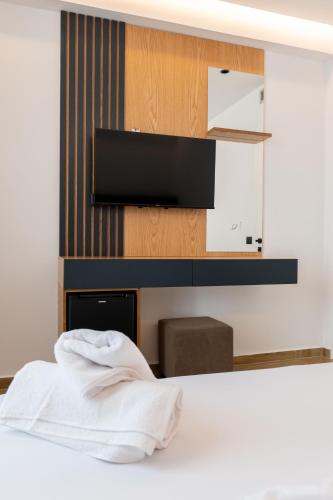 a bedroom with a bed with a tv on a wall at Alpaso Hotel in Sarandë