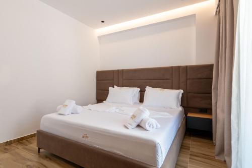 a bedroom with a large bed with white sheets and pillows at Alpaso Hotel in Sarandë