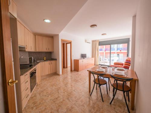 a kitchen with a table and two chairs and a table at Apartaments AR Easy Santa Anna II in Lloret de Mar