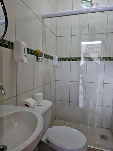a white bathroom with a toilet and a sink at Cantinho da LAGO in Itacuruçá