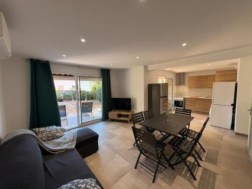 un salon avec une table et une cuisine dans l'établissement Fabuleux T3 avec grand jardin - Sainte-Maxime, à Sainte-Maxime