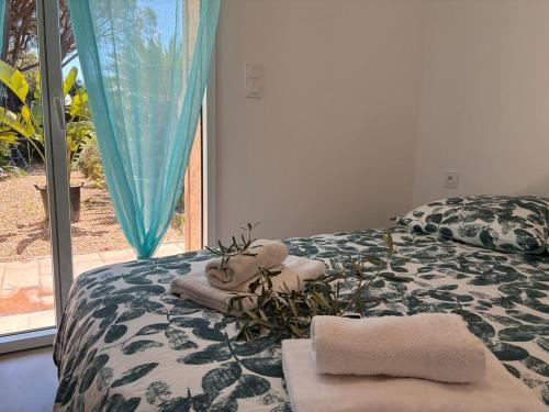 - une chambre avec un lit, des serviettes et une fenêtre dans l'établissement Fabuleux T3 avec grand jardin - Sainte-Maxime, à Sainte-Maxime