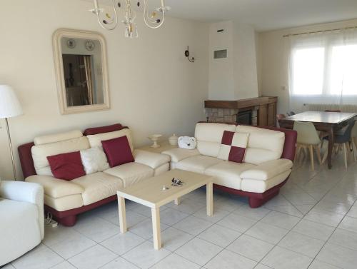 un salon avec deux canapés et une table dans l'établissement Maison avec grand jardin et terrasse plein sud 1, à Lion-sur-Mer