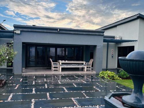 a patio with a bench in front of a house at Pula Nala Lodge Bed & Breakfast in Rustenburg