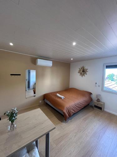 a bedroom with a bed and a table in it at Cozy studio proche Zenith, A75 "émile" in Cournon-dʼAuvergne