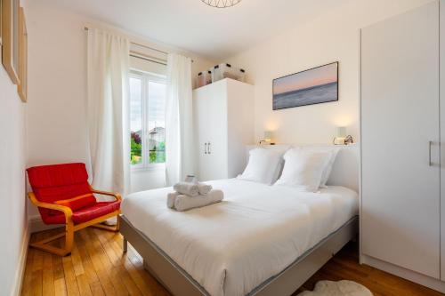 une chambre avec un lit et une chaise rouge dans l'établissement Le Plaisant d'Haussonville - Joli T2 Nancy, à Nancy