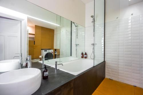 une salle de bain avec un lavabo et une baignoire dans l'établissement Le Plaisant d'Haussonville - Joli T2 Nancy, à Nancy