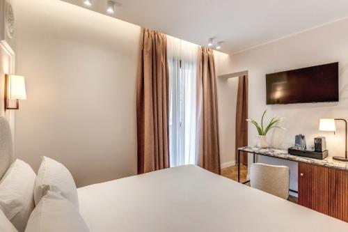 a hotel room with a bed and a tv at Hotel Fori Imperiali in Rome