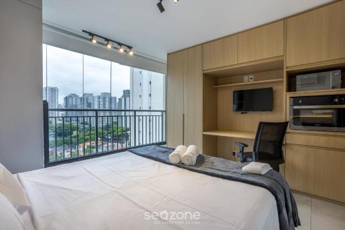Schlafzimmer mit einem Bett und Stadtblick in der Unterkunft Studio Moderno a 450m do Metrô – ISM0806 in São Paulo