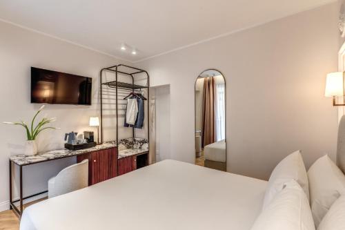 a white bedroom with a bed and a mirror at Hotel Fori Imperiali in Rome