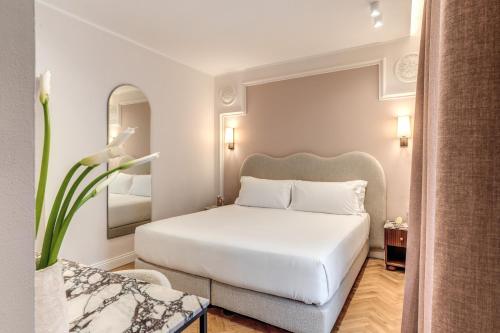 a bedroom with a white bed and a mirror at Hotel Fori Imperiali in Rome