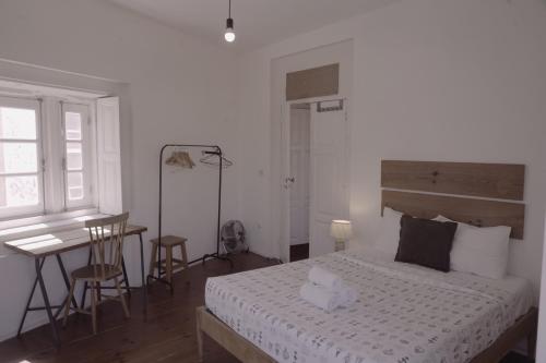 a bedroom with a bed and a table and a desk at Light & Airy Historic Centre House with Balconies in Porto