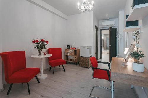 un soggiorno con sedie rosse e un tavolo di Athens Point ad Atene