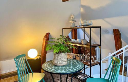 a table with chairs and a potted plant on it at Cozy Apartment In Borås With Wifi in Borås