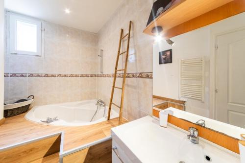 une salle de bain avec une baignoire et un lavabo dans l'établissement L'Arcane - Appt climatisé, à Agen