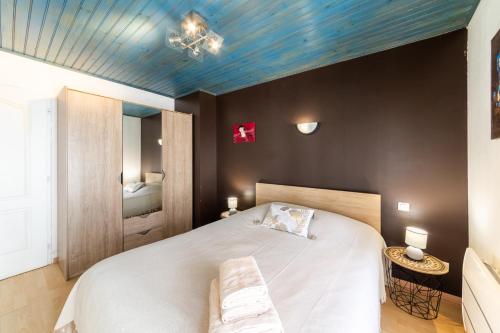 une chambre avec un grand lit avec un plafond bleu dans l'établissement L'Arcane - Appt climatisé, à Agen