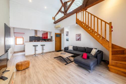 un salon avec un canapé et un escalier dans l'établissement L'Arcane - Appt climatisé, à Agen