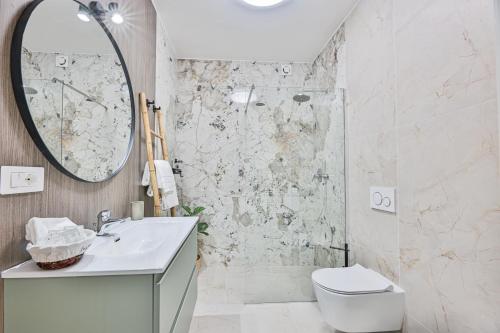 a bathroom with a sink and a toilet and a mirror at SUITE ELEVEN ISOLA D'ELBA in Bagnaia