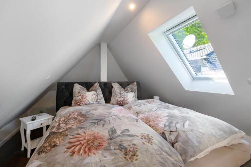 a bedroom with a bed with pillows and a window at Strandhus 22 in Graal-Müritz