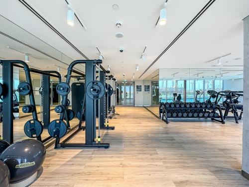 迪拜Grand 3BR APT with Pool, Gym and 2 Parking Spaces的配有一排跑步机和器械的健身房