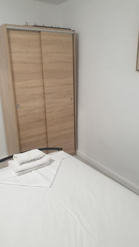 a white bed in a room with a closet at ERRIKA in Ermoupoli
