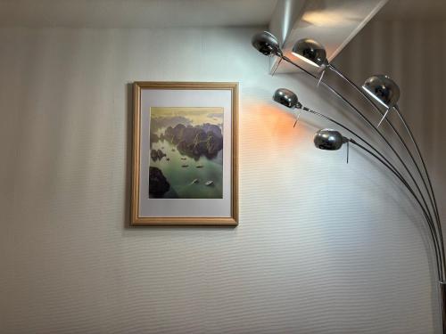 a lamp on a wall with a picture on it at Le Poisat in Pont-de-Vaux