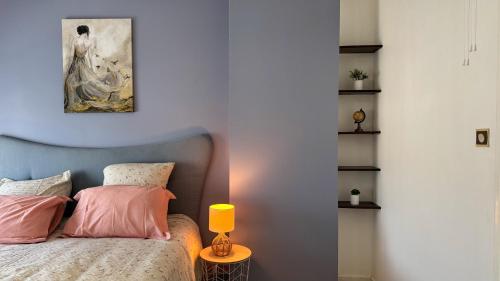 a bedroom with a bed with a lamp on a table at Le Poisat in Pont-de-Vaux