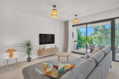 a living room with a couch and a tv at Townhouse Eden Golf Chaparral in Málaga