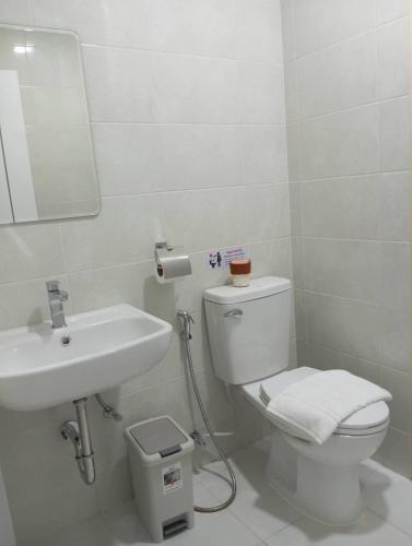 a bathroom with a white toilet and a sink at VS Place in Nonthaburi