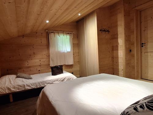 - une chambre avec 2 lits dans une cabane en bois dans l'établissement Appart. cosy 5 pers. proche pistes et navette, balcon sud - FR-1-467-26, au Grand-Bornand