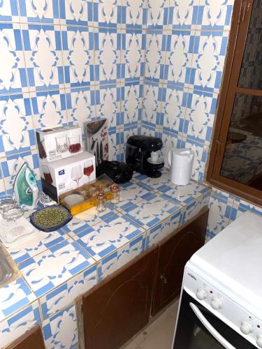 a kitchen counter with blue and white tiles at Résidence Woyanko in Bamako