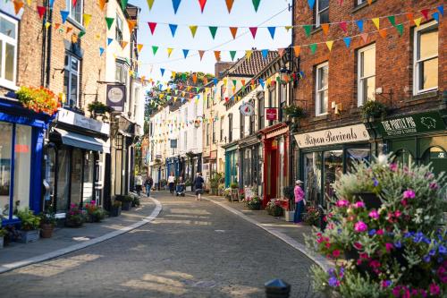 a city street with flags and flowers and buildings at Number 19 in Ripon