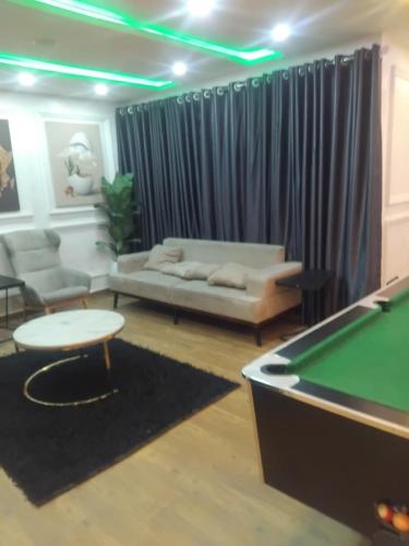 a living room with a couch and a pool table at M&S Luxury Apartment in Lekki