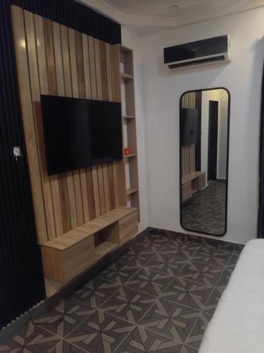 a room with a television and a mirror at M&S Luxury Apartment in Lekki