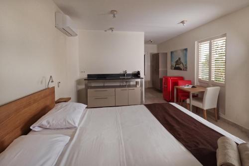 a bedroom with a large bed and a kitchen at Chogogo Dive & Beach Resort Curaçao in Jan Thiel