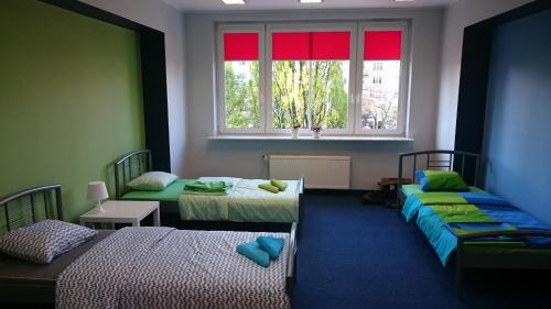 a room with two beds and a window at HELLO Gdynia Hostel in Gdynia
