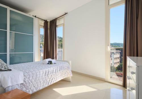 a bedroom with a bed and a large window at Apartments MTB Only Couples in Lloret de Mar