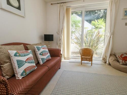 a living room with a couch and a large window at 6 Red Sails in Poole