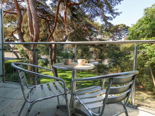 a table and two chairs sitting on a porch at 6 Red Sails in Poole