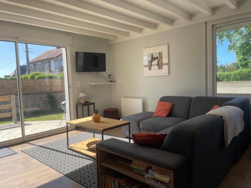 a living room with a couch and a table at Horizon Vert by Melrose in Asnelles