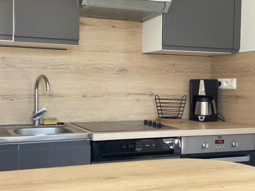 a kitchen with a sink and a counter top at Horizon Vert by Melrose in Asnelles
