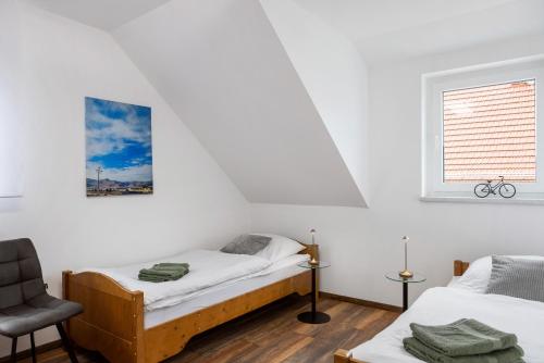 a bedroom with two beds and a chair at Ferienwohnung Rhön-Kutscher in Buttlar