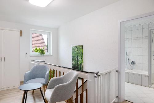 a white staircase with two chairs and a table at Ferienwohnung Rhön-Kutscher in Buttlar