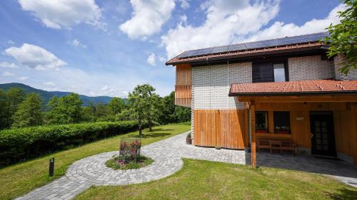 a building with a patio next to a house at Hiša na Hribu- A Peaceful Hilltop Escape above river Kolpa in Kostel