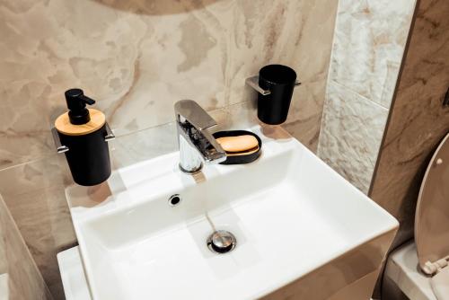 a bathroom with a sink with two cups on it at Fruška Kuća in Vrdnik