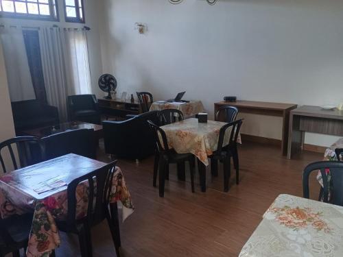 a dining room with tables and chairs in a room at Pousada cravo & canela in Maringá